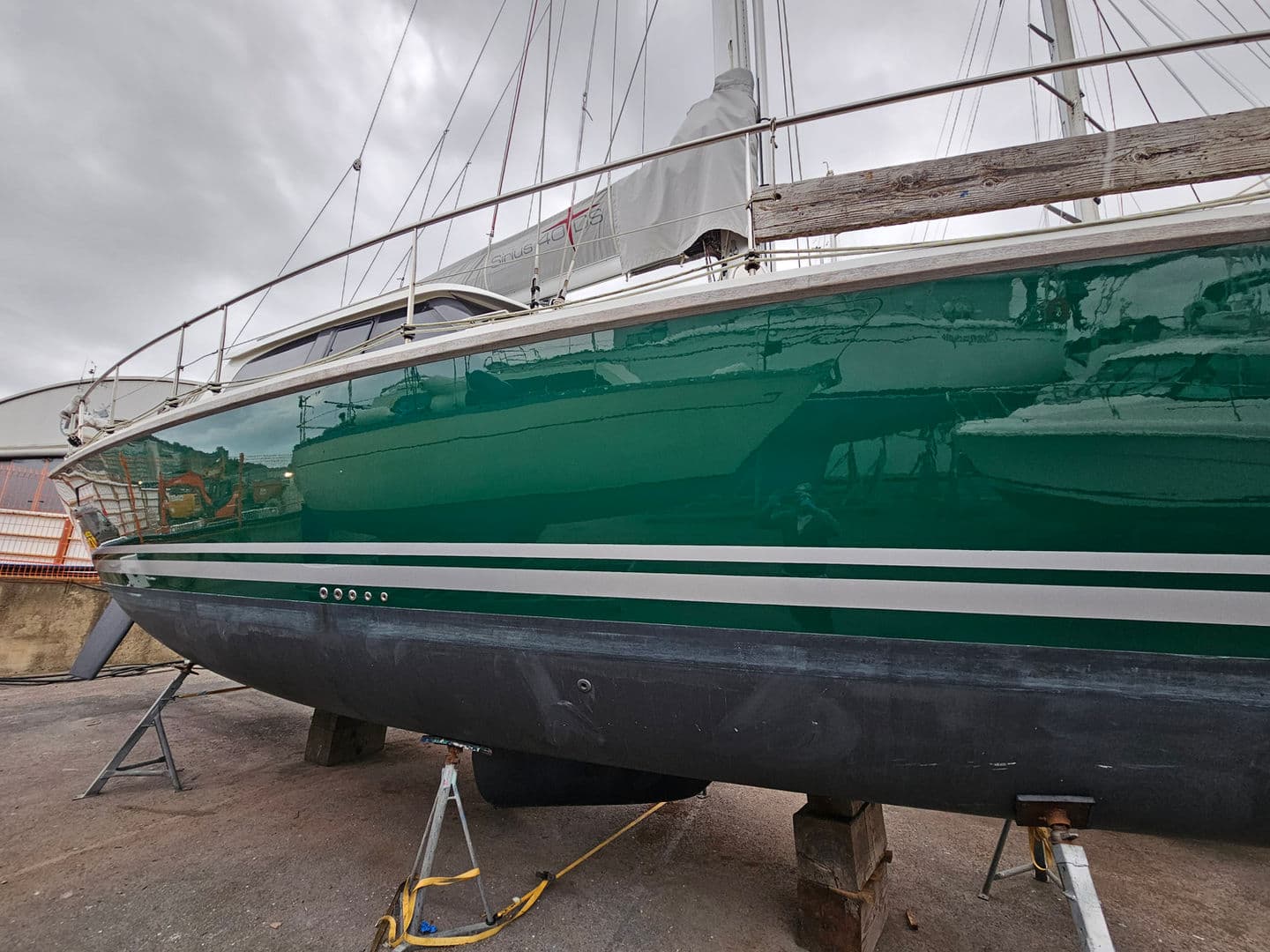 Alsephina's green hull with a full-length gloss finish in the boatyard