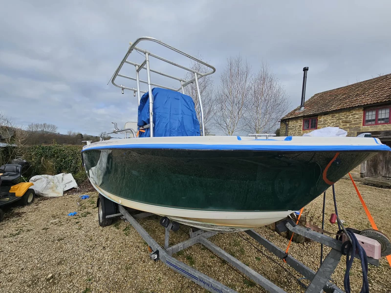 Trophy centre console's toe-rail finished in gloss white after storm damage repair, sunny boatyard