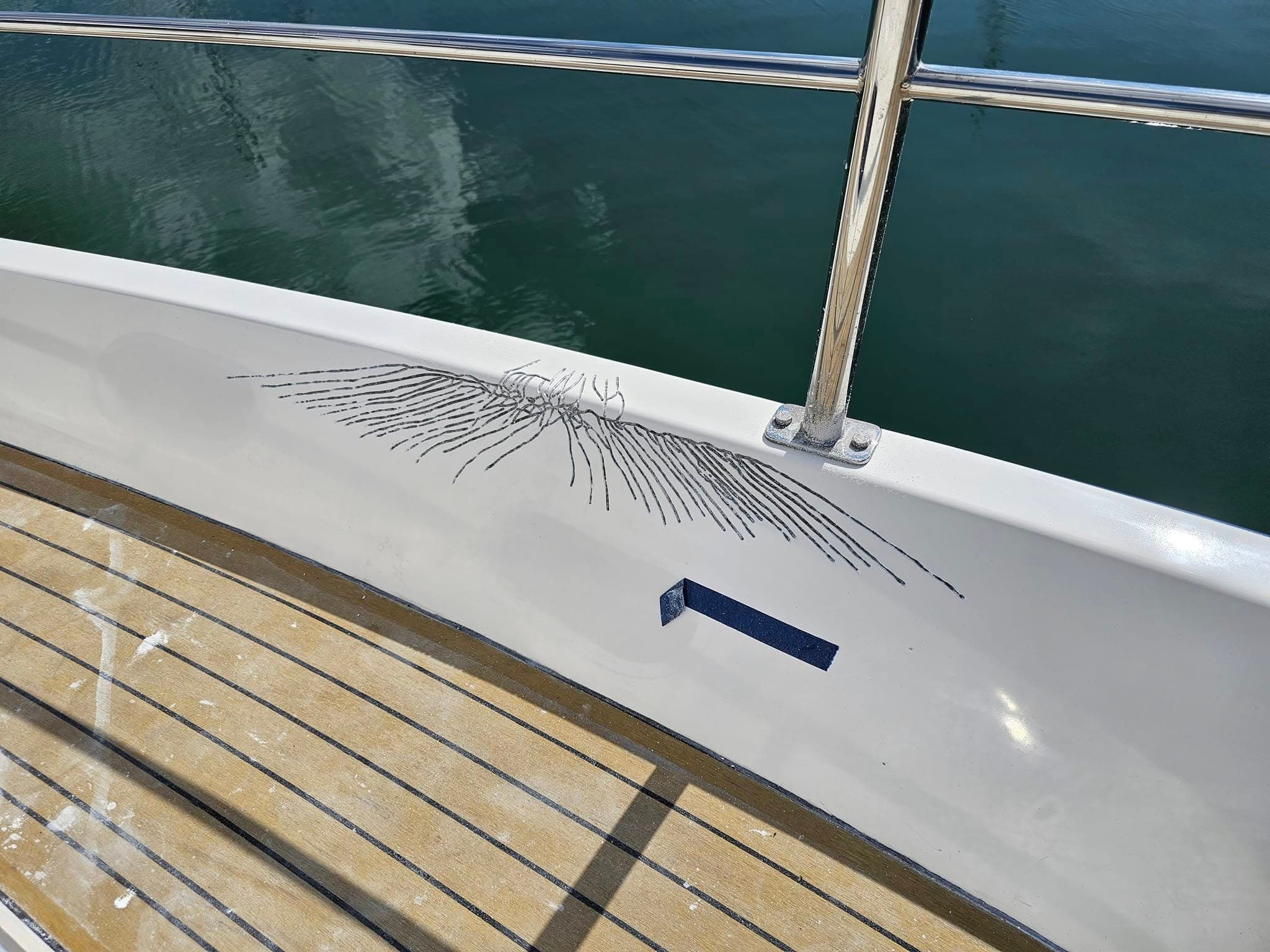 White and navy bow with spider cracks masked off ready for gelcoat repair